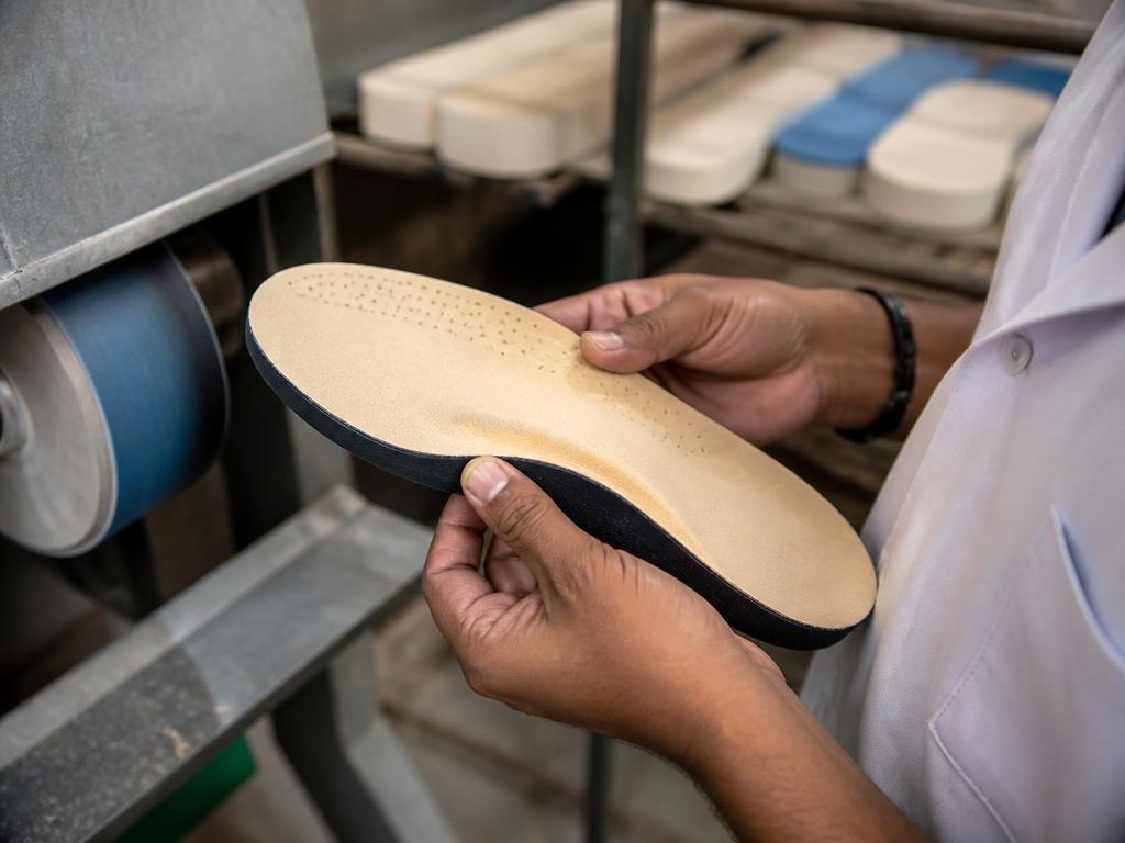 Technician shaping a custom orthopaedic insole in the workshop